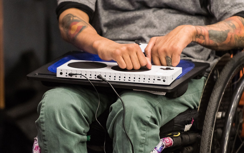 A person in a wheelchair uses the XBOX Adaptive Controller.