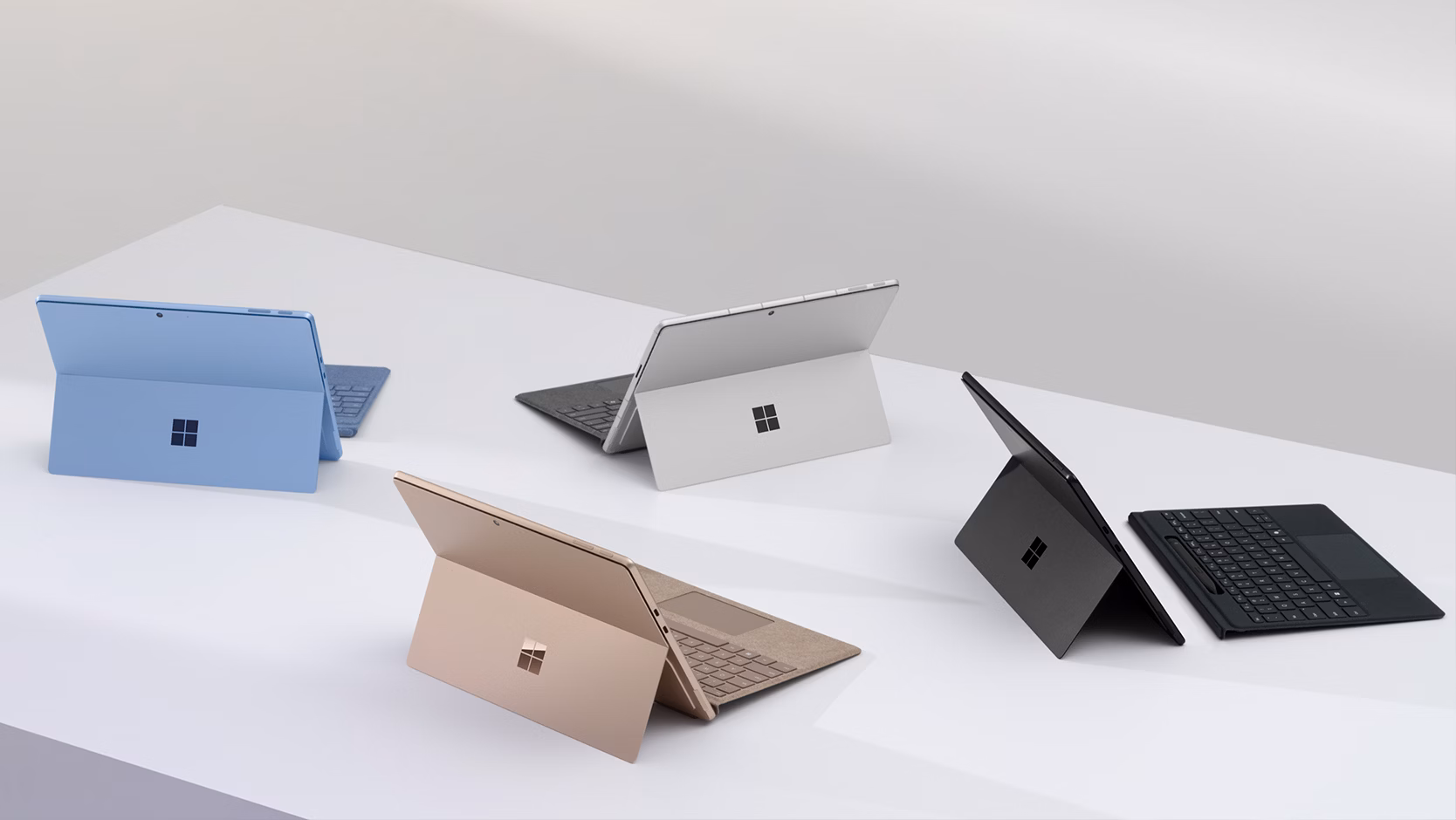 Cuatro dispositivos Teclado para Surface Pro con almacenamiento de lápiz en negro, platino, zafiro y duna.