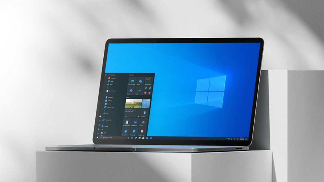 Windows 10 홈 화면이 열린 채 흰색 기둥 위에 놓여 있는 노트북.