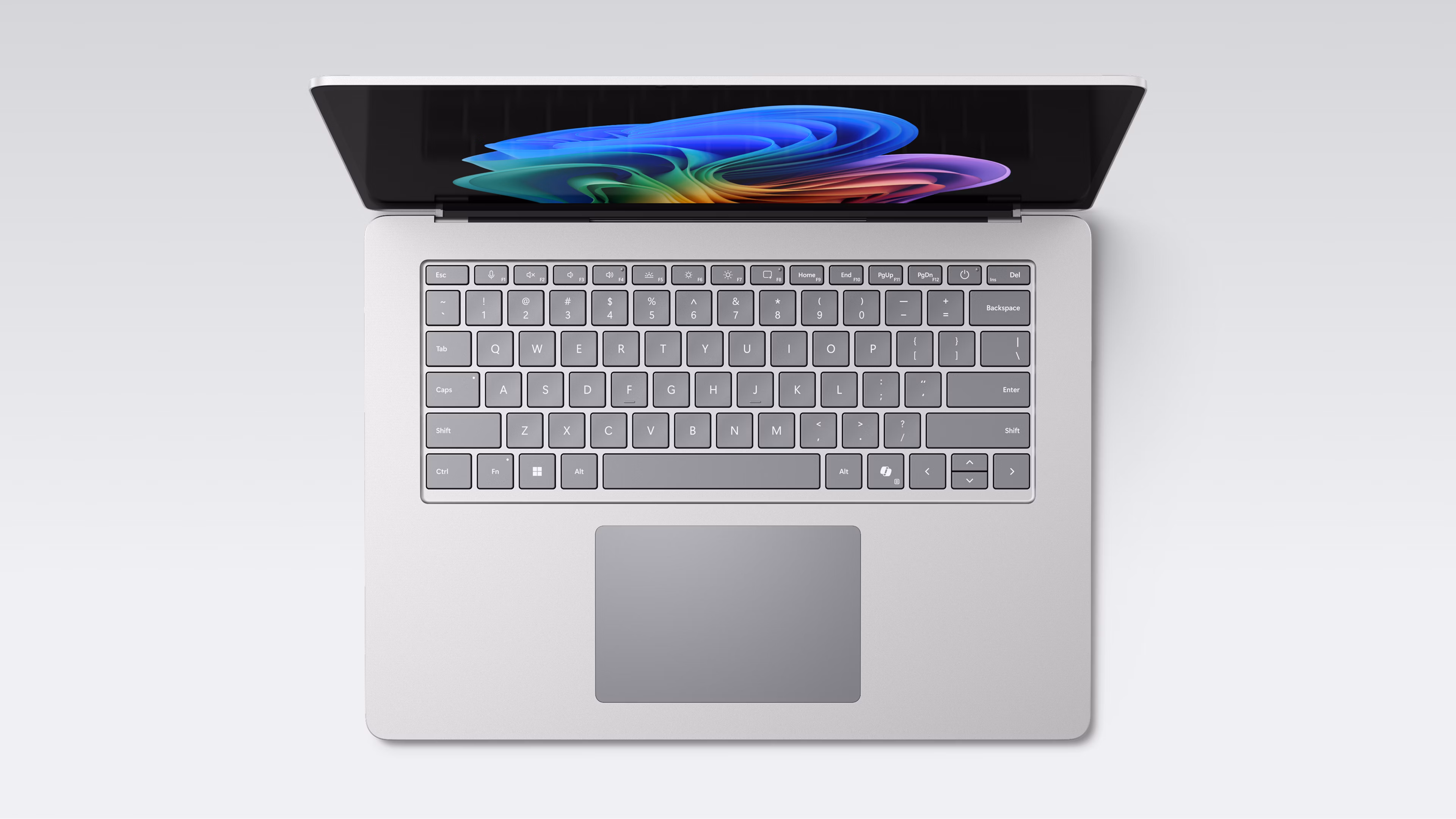 Een open chromen Surface Laptop van bovenaf gezien met de regenboogbloem op het scherm, een volledig toetsenbord en een groot touchpad.